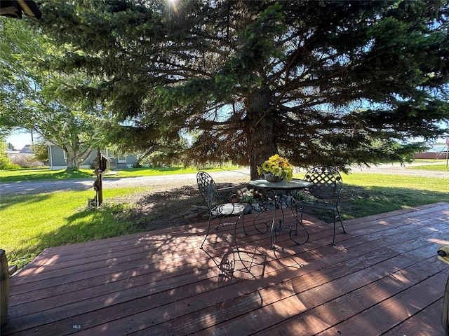 wooden terrace featuring a lawn