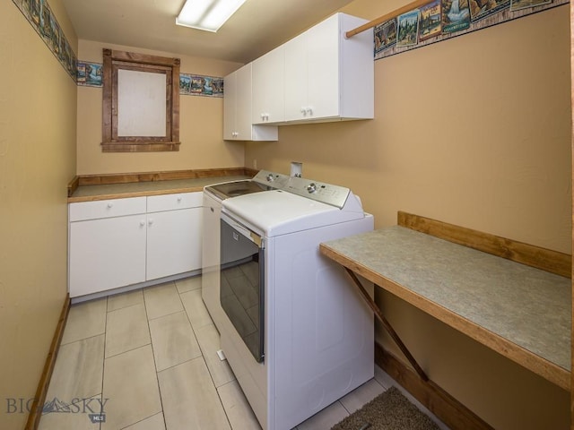 laundry room featuring cabinets, washing machine and dryer, and light tile patterned floors