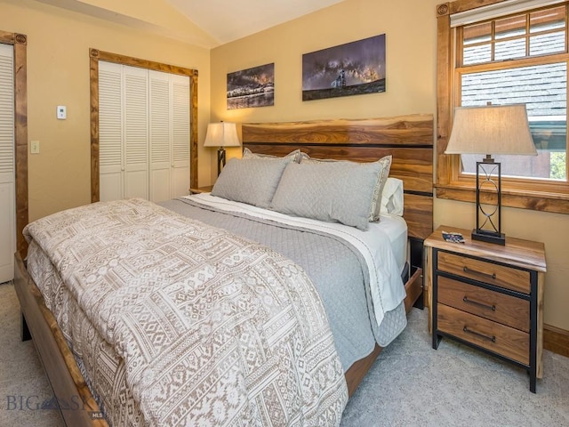 bedroom featuring vaulted ceiling, light colored carpet, and a closet