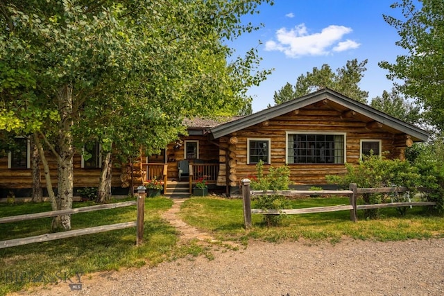 cabin with fence and log siding