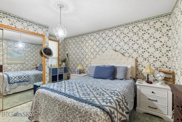 bedroom featuring a notable chandelier, a textured ceiling, and carpet