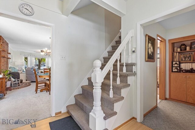 stairway featuring a chandelier and carpet floors