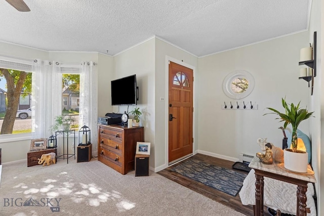 entryway with ceiling fan, a textured ceiling, ornamental molding, a baseboard radiator, and hardwood / wood-style flooring