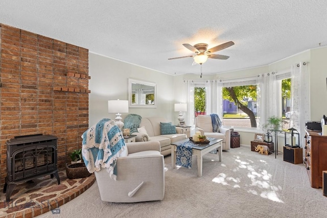 living room with a textured ceiling, brick wall, a wood stove, carpet, and ceiling fan