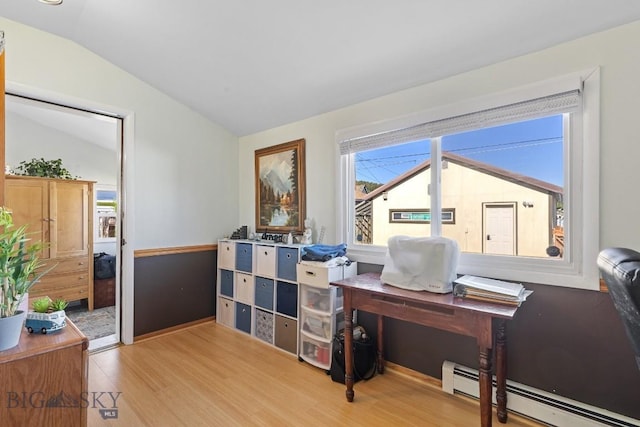 office area with a baseboard radiator, light hardwood / wood-style floors, and lofted ceiling