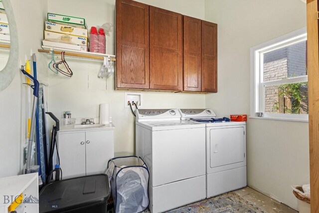 clothes washing area featuring hookup for a washing machine, separate washer and dryer, and cabinets