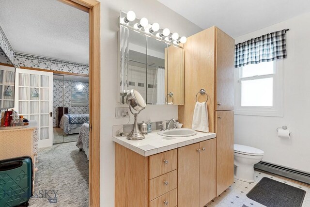 bathroom with tile flooring, a textured ceiling, a baseboard radiator, toilet, and vanity