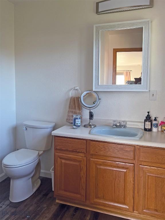 bathroom featuring wood-type flooring, toilet, and vanity