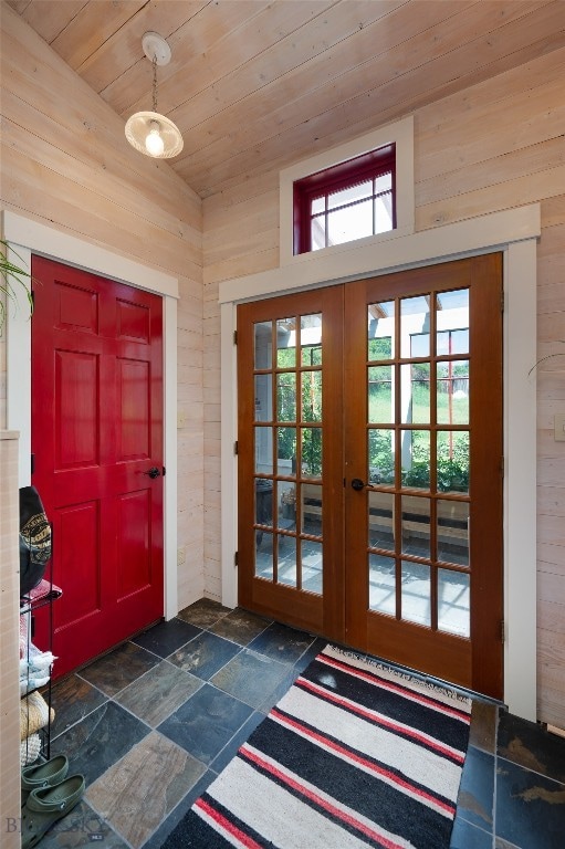 entryway with a towering ceiling, wood walls, french doors, and wooden ceiling