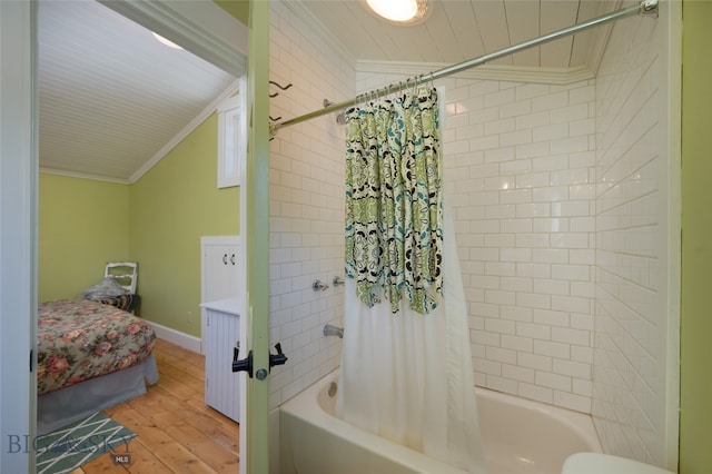 bathroom with wood-type flooring, toilet, shower / bath combo with shower curtain, and ornamental molding