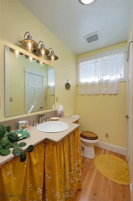 bathroom featuring wood-type flooring, vanity, and toilet