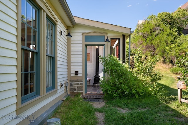 doorway to property with a lawn