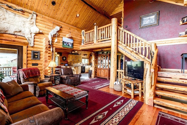 living room with rustic walls, wood ceiling, beamed ceiling, hardwood / wood-style floors, and high vaulted ceiling