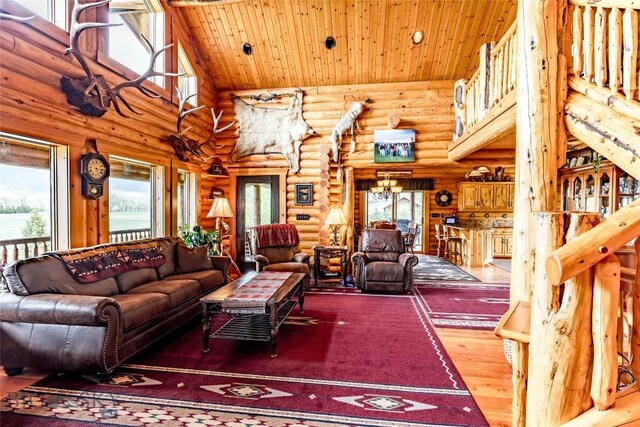 living room with wood ceiling, rustic walls, high vaulted ceiling, wood-type flooring, and a notable chandelier