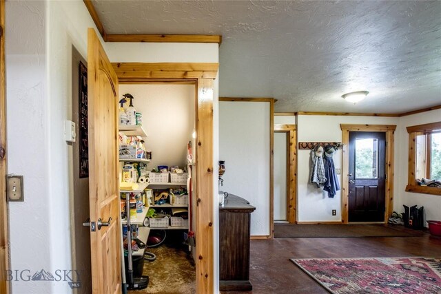 entryway with crown molding and a textured ceiling