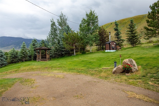 view of yard with a storage shed, a mountain view, and a gazebo