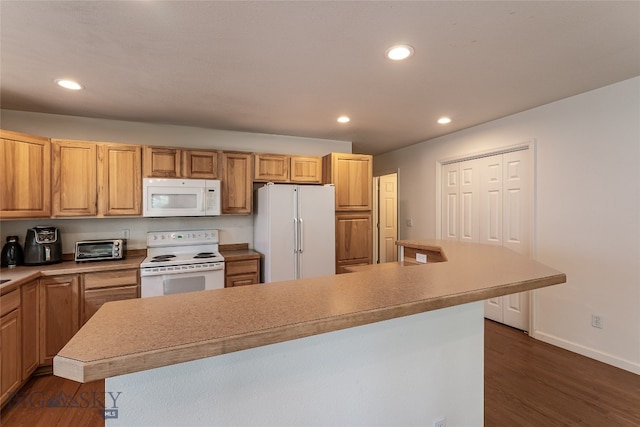 kitchen featuring dark hardwood / wood-style flooring, a kitchen island, and white appliances