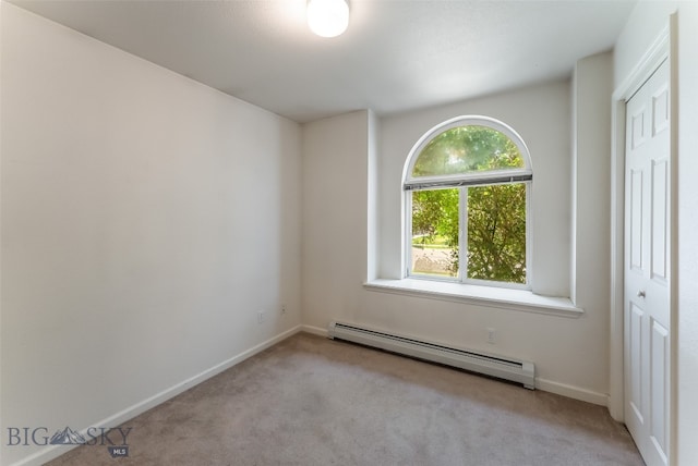 spare room featuring a baseboard radiator and carpet flooring