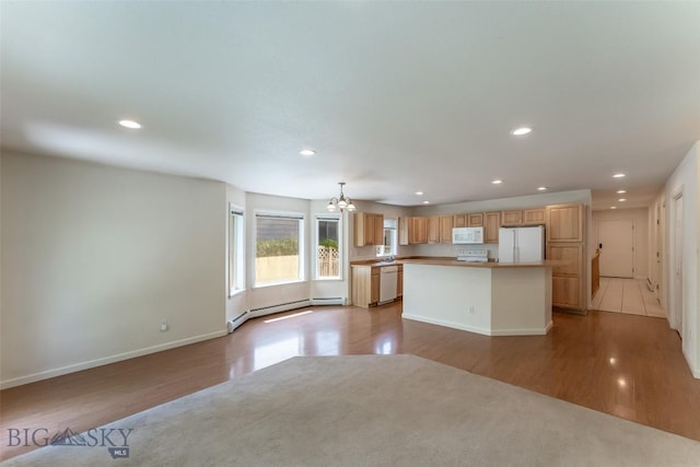 kitchen featuring recessed lighting, a center island, white appliances, and a chandelier