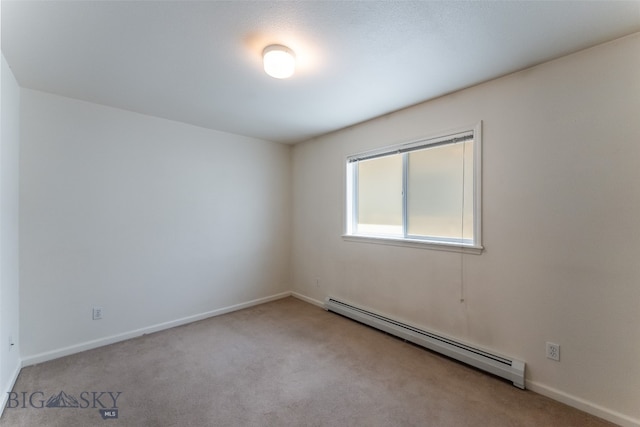 carpeted spare room with a baseboard radiator