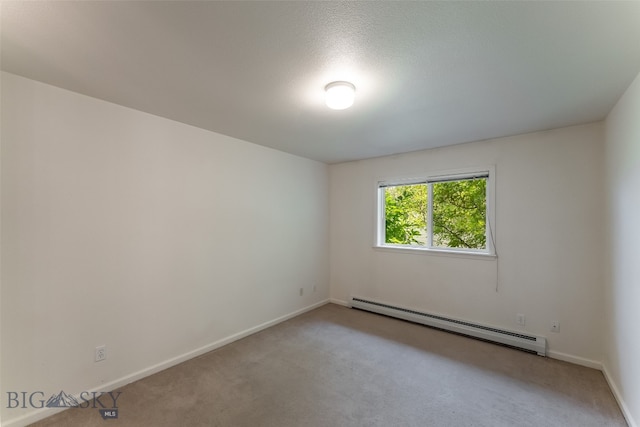 unfurnished room featuring carpet and a baseboard heating unit