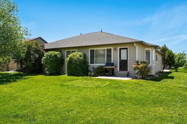 rear view of house featuring a lawn