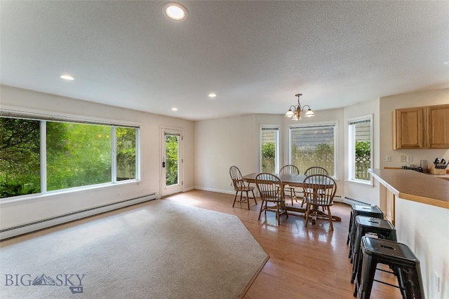 dining space with baseboards, a baseboard radiator, light wood finished floors, a notable chandelier, and recessed lighting