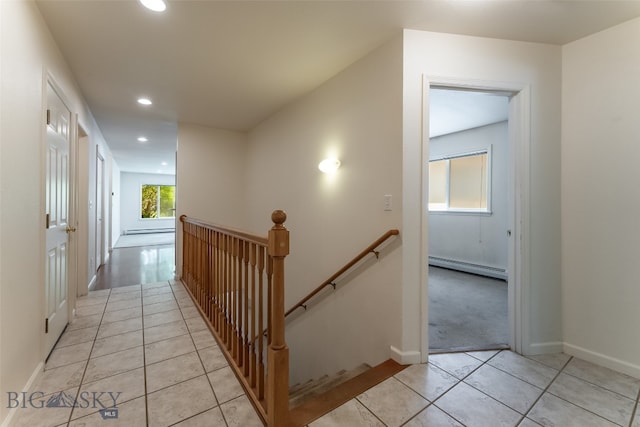 hallway with a baseboard heating unit and light tile patterned floors