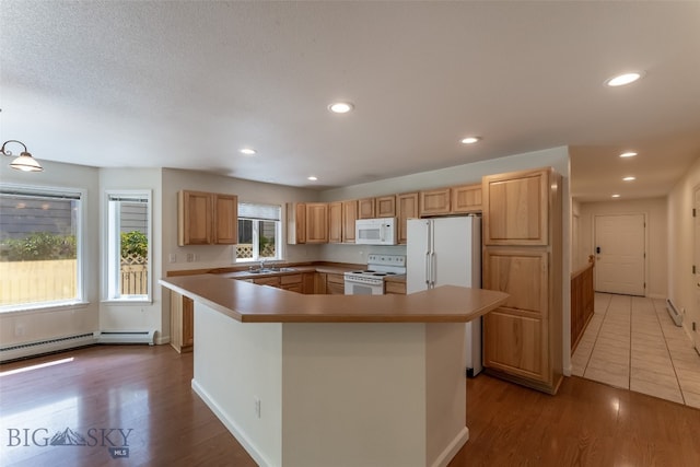 kitchen featuring sink, white appliances, light wood-type flooring, and plenty of natural light