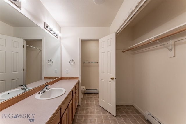 bathroom with vanity, a baseboard radiator, toilet, and tile patterned floors