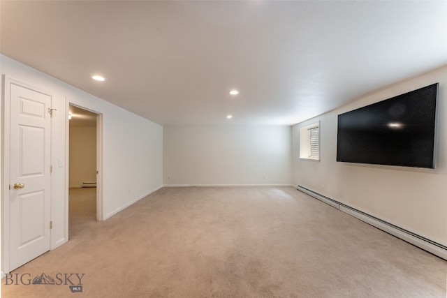 carpeted empty room featuring a baseboard heating unit