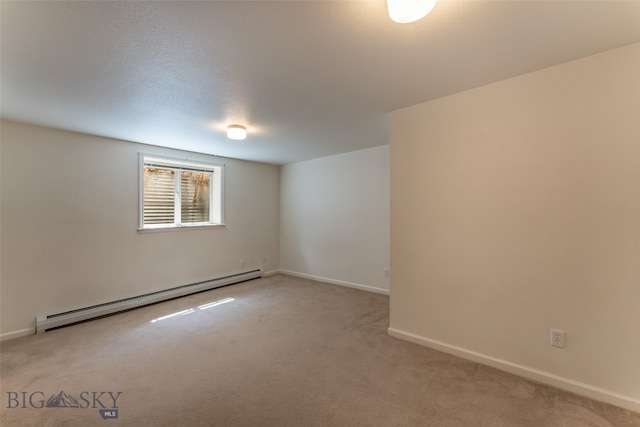 unfurnished room with a baseboard radiator and carpet