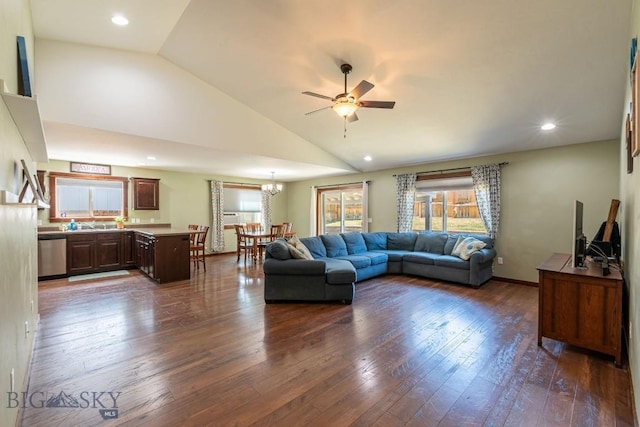 living room featuring ceiling fan with notable chandelier, dark hardwood / wood-style flooring, and high vaulted ceiling