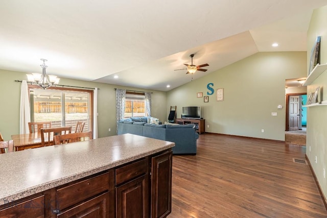 kitchen with dark hardwood / wood-style floors, pendant lighting, vaulted ceiling, dark brown cabinets, and ceiling fan with notable chandelier