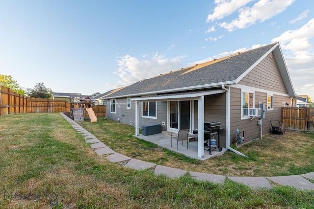 rear view of property with a lawn, a patio area, and a playground