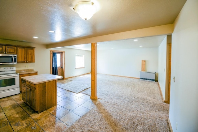 kitchen featuring a kitchen island, electric stove, a textured ceiling, and dark carpet