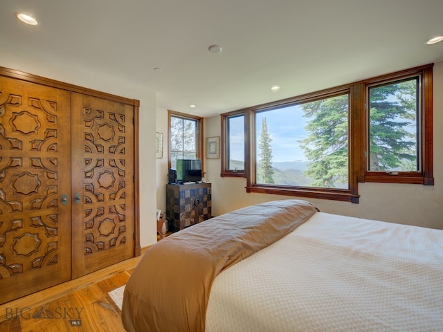 bedroom with french doors and hardwood / wood-style floors