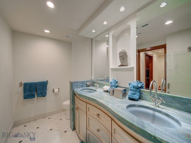 bathroom featuring tile patterned flooring, dual vanity, and toilet