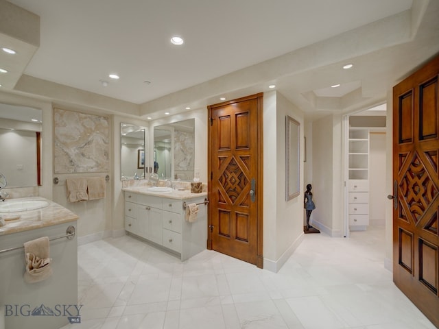 bathroom featuring tile patterned floors, a raised ceiling, and vanity