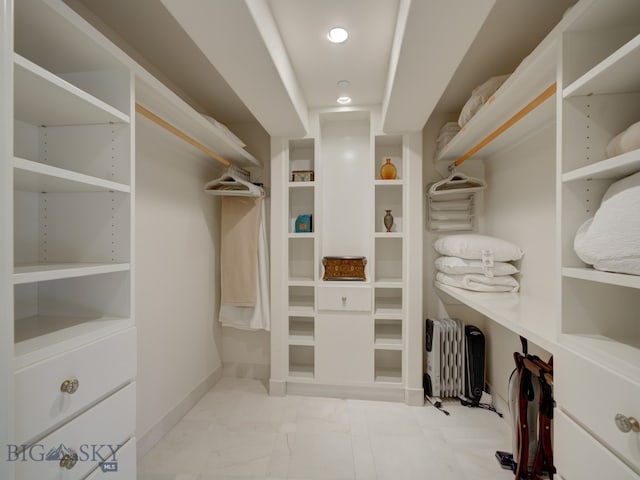 spacious closet with radiator heating unit and light tile patterned floors