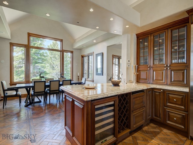 interior space featuring high vaulted ceiling, wine cooler, light stone counters, and dark parquet flooring