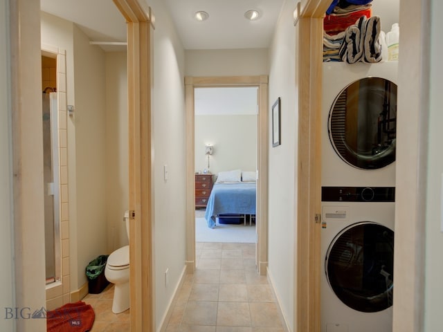 laundry area with stacked washer / dryer and light carpet