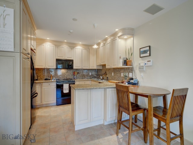 kitchen featuring backsplash, black appliances, light stone counters, and light tile patterned floors