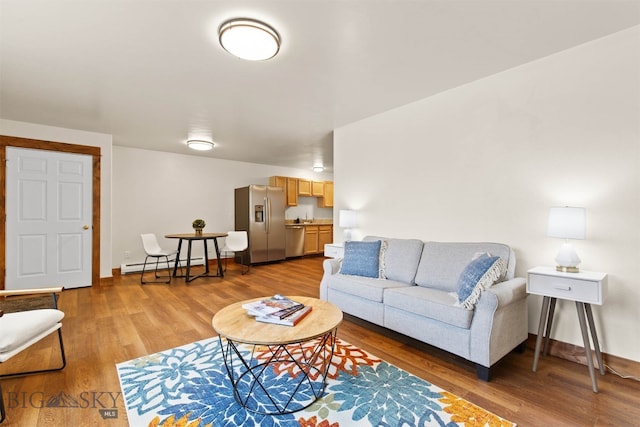 living room with a baseboard heating unit and light wood-type flooring