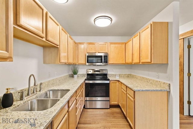 kitchen with sink, stainless steel appliances, light stone countertops, and light brown cabinets