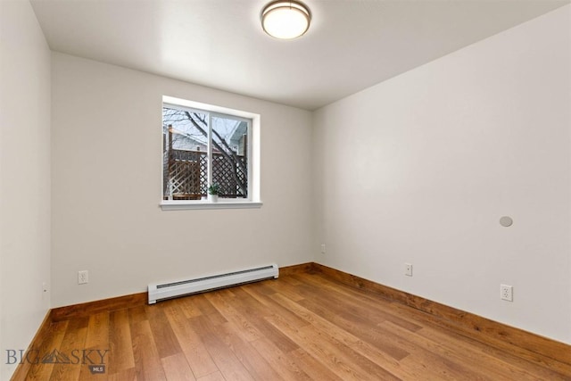 spare room with a baseboard radiator and light hardwood / wood-style floors