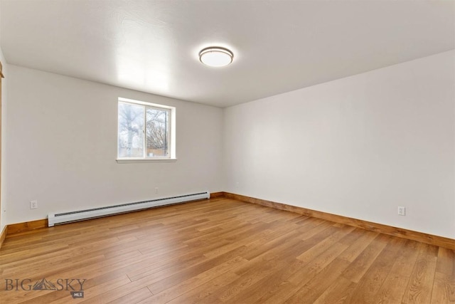 unfurnished room featuring a baseboard radiator and light wood-type flooring