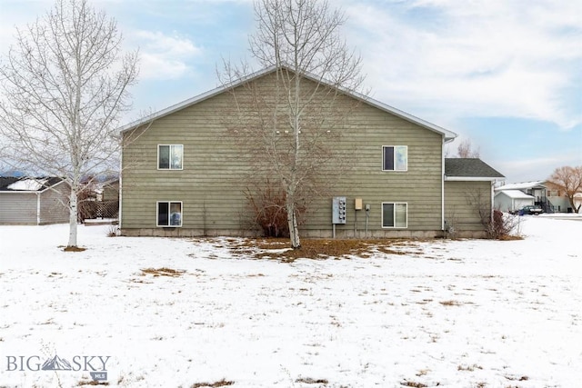 view of snow covered back of property