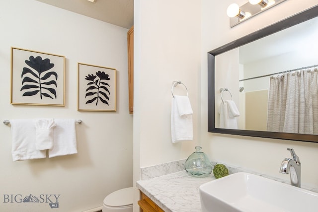 bathroom featuring a shower with shower curtain, vanity, and toilet