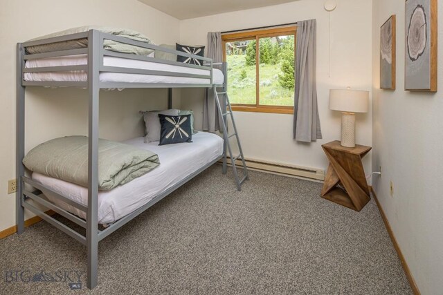 bedroom with carpet flooring and a baseboard heating unit